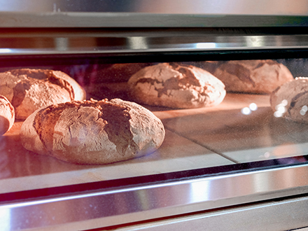 Nahaufnahme von Broten, die in einem Backautomaten gebacken werden