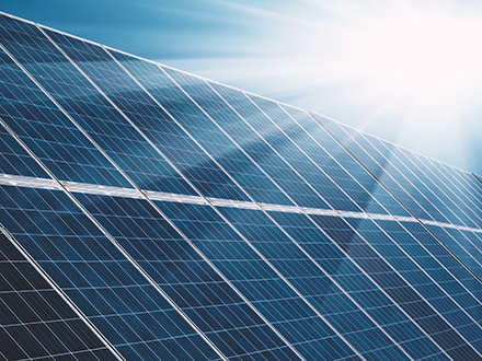 Nahaufnahme von blauen Photovoltaik-Modulen unter klarem Himmel im Sonnenlicht